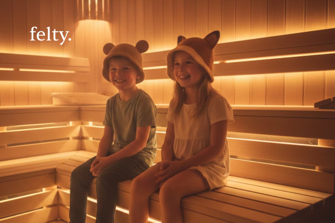 Young friends sport adorable, animal-themed sauna hats as they relax in the soothing, amber-toned light of the sauna setting.