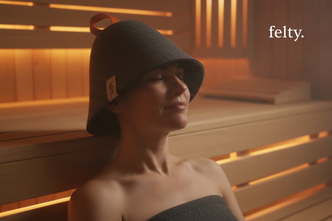 This image depicts an individual wearing a specialized sauna hat designed to provide temperature regulation and comfort during a wellness session.