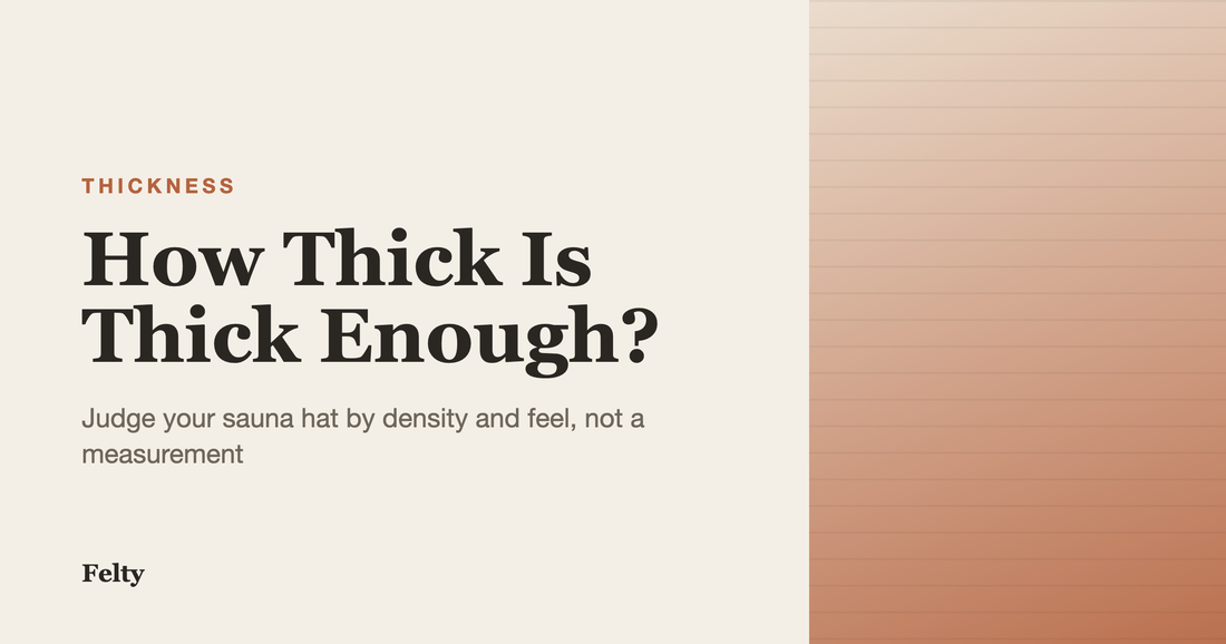 A thick, dense wool sauna hat held in hand on a cedar bench, showing the substantial felt that determines sauna hat thickness